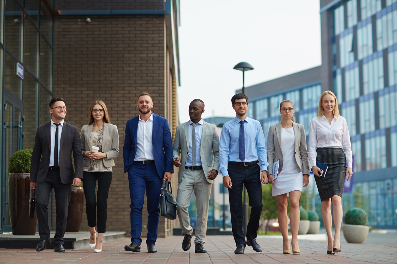 A diverse team of B2B sales professionals walking together outside a modern office